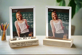 Two photo frames on stands with a person and inspirational text, placed on a surface.